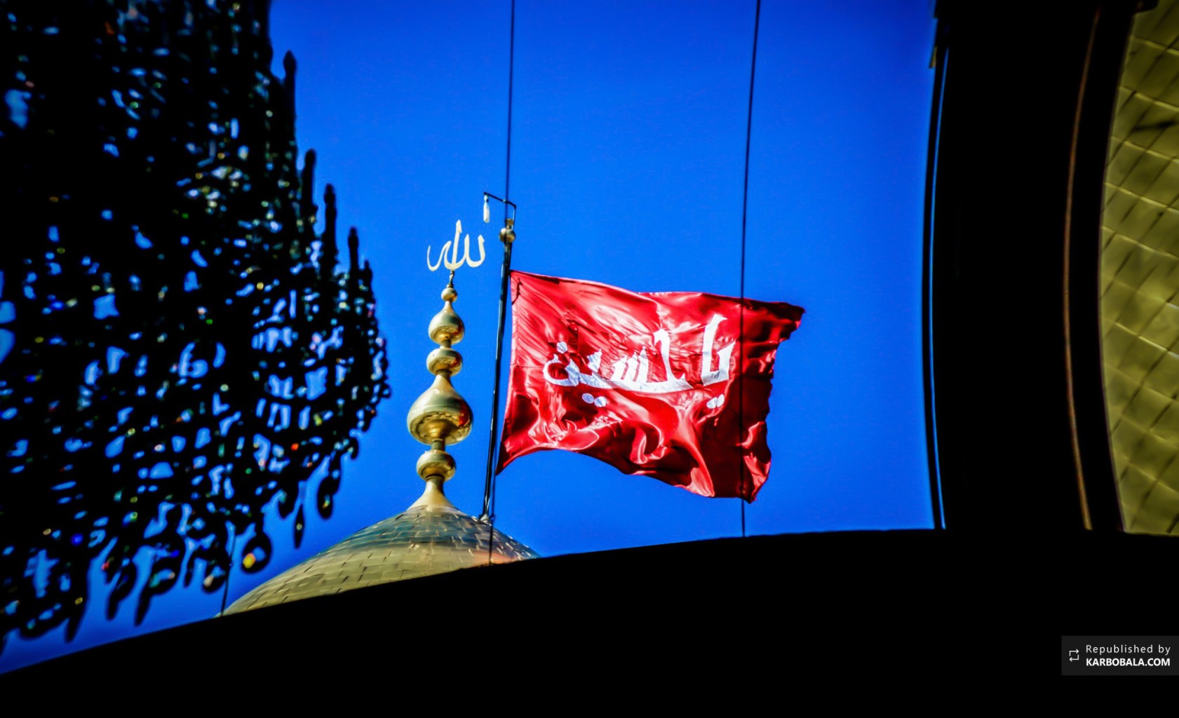 پرچم سرخ حسینی برافراشته بر گنبد طلایی آن حضرت