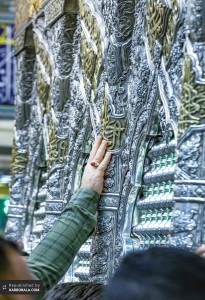 دخیل و توسل زائر به ضریح مبارک امام حسین (ع)‌